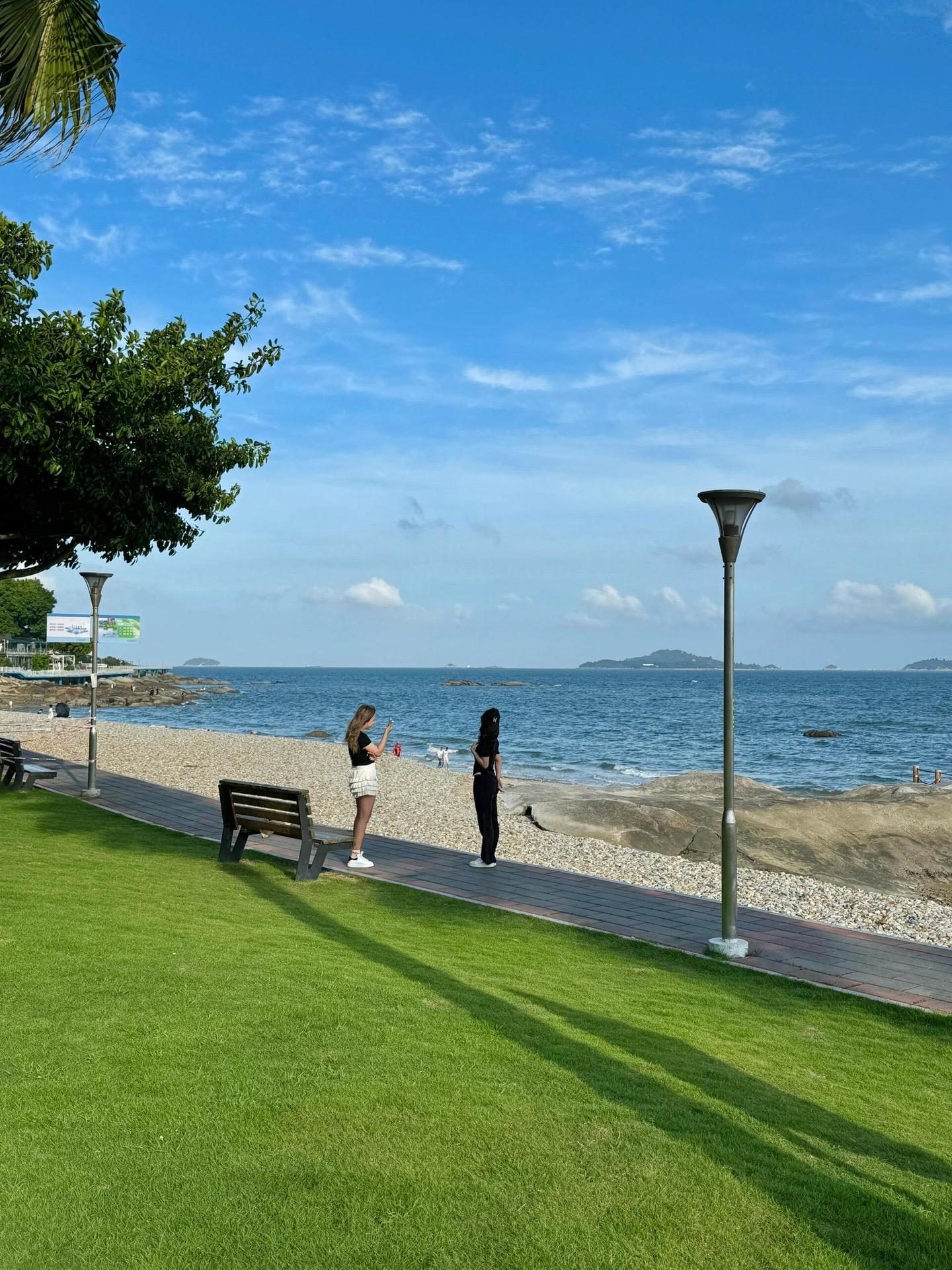 Visitors on the seafront promenade in Xiamen on a clear day