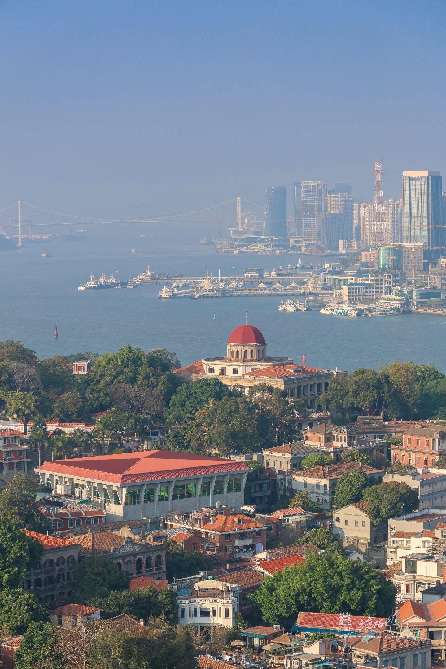 The red dome of Bagua Mansion above the rooftops of Gulangyu, with the Xiamen waterfront across the strait