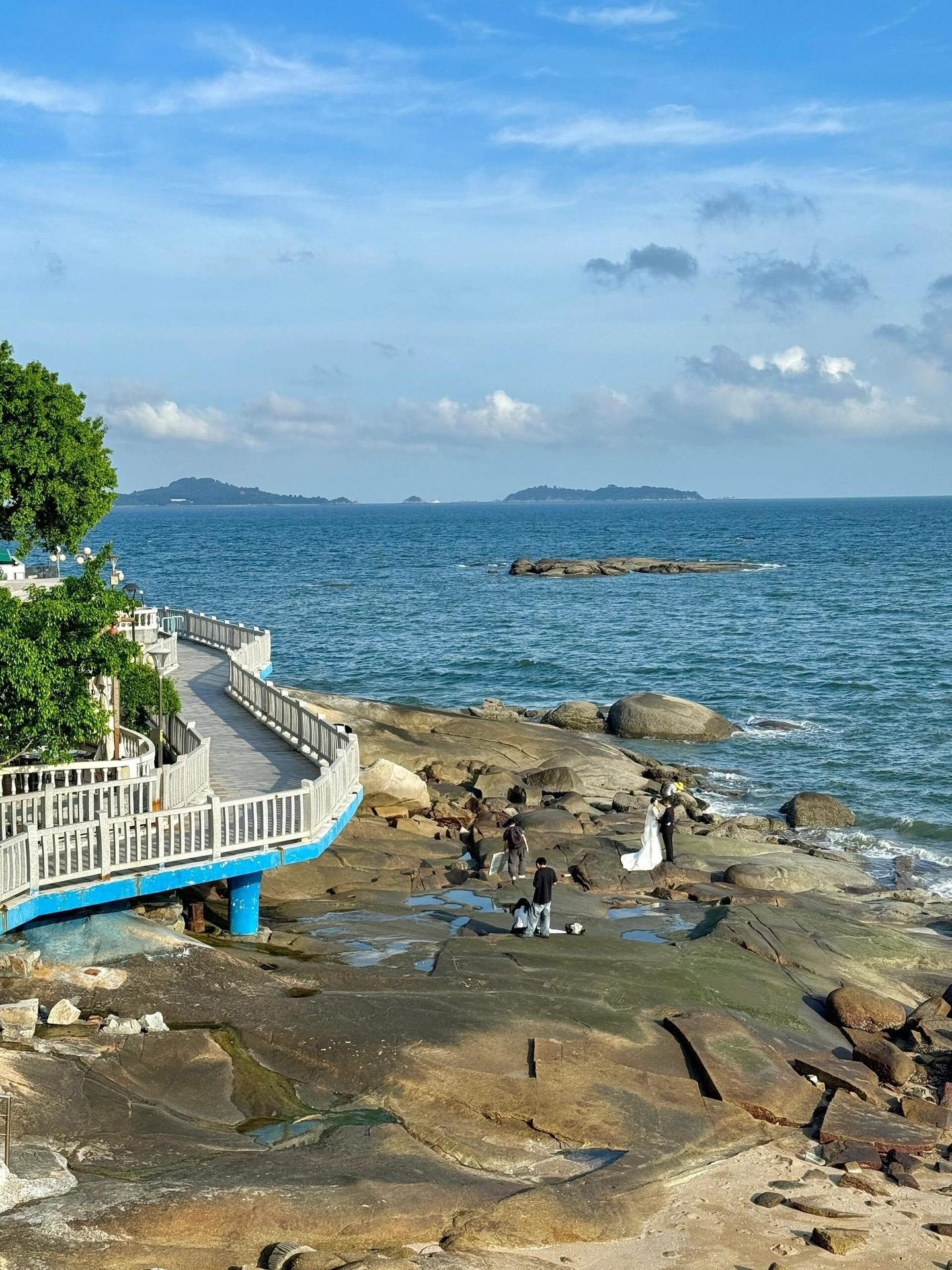 A coastal path winding past rocks and blue sea on the Fujian coast at Xiamen