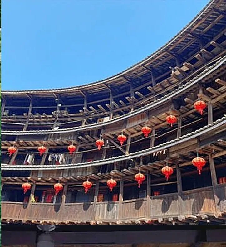 Inside a circular Fujian Tulou earth building hung with red lanterns